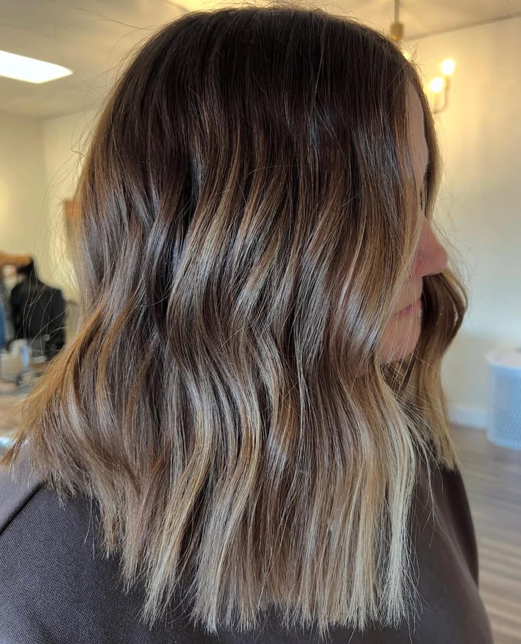 Lived-in blonde balayage on a wavy lob, colored by Amanda